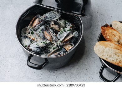 Cooked Oysters In A Pot Sprinkled With Parmesan And Greens. Fried Toasts In A Next Pot. On A Table