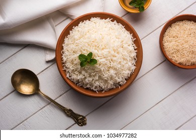 Cooked plain white basmati rice in terracotta bowl over plain or wooden background
