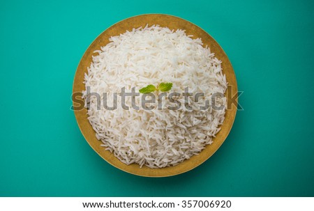cooked plain white basmati rice served in a brass bowl or plate, isolated over colourful or wooden background