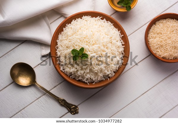 Cooked plain white basmati rice in\
terracotta bowl over plain or wooden\
background\
