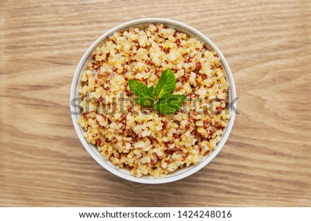 Cooked quinoa bowl on wood background