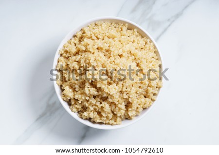 Cooked quinoa in white bowl, top view