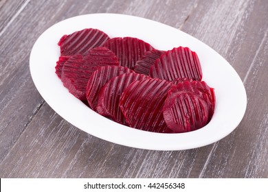 Cooked red slices beetroot  in plate on wooden background. - Powered by Shutterstock