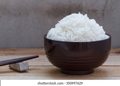 Cooked Rice In Bowl On Wood Background.