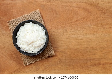 Cooked Rice In Bowl On Wooden Table. Top View And Copy Space