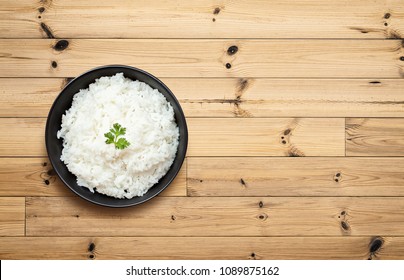 Cooked Rice In Bowl On Wooden Table. Top View And Copy Space