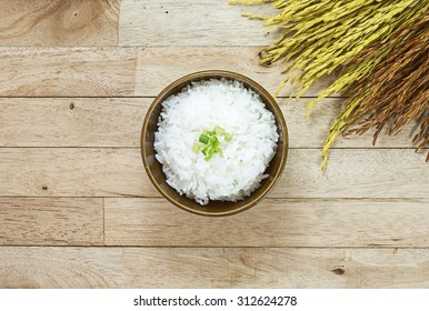 Cooked Rice And Paddy Rice On Wood Table At Top View