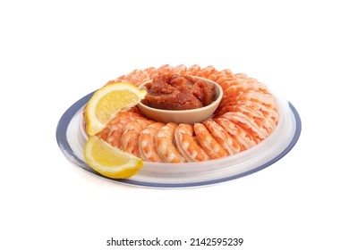 A Cooked Shrimp Ring With Cocktail Sauce And Lemon Slices Isolated On White