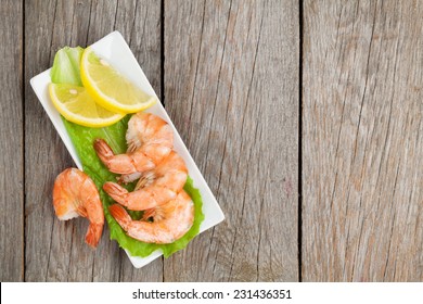 Cooked Shrimps With Lemon And Salad Leaves. View From Above On Wooden Table With Copy Space