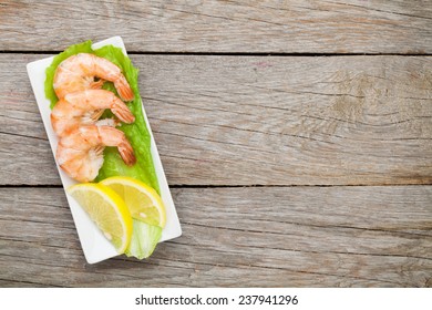 Cooked Shrimps With Lemon And Salad Leaves. View From Above On Wooden Table With Copy Space