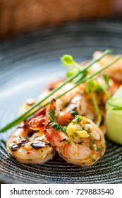 Cooked shrimps with sauce and vegetables, tomato, cucumber and lemon