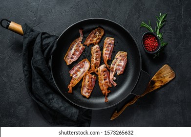 Cooked Sizzling Hot Tasty Crispy Bacon On A Skillet. Farm Organic Meat. Black Background. Top View