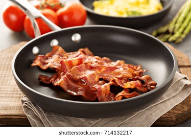 Cooked Sizzling Hot Tasty Crispy Bacon On A Skillet And Scrambled Eggs Ready For Breakfast