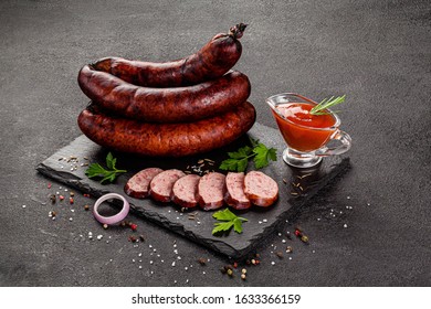 Cooked, smoked products, sausages chicken. Sausage meat products on a gray background with spices. background image, copy space text