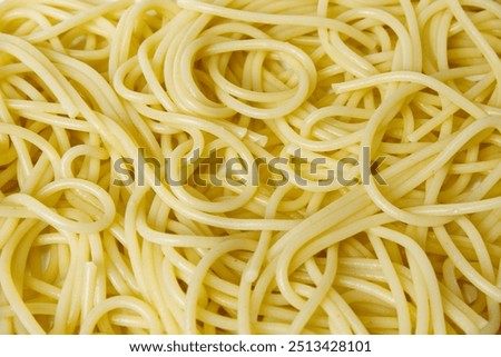 Cooked spaghetti background. Close-up spaghetti texture with concept of abstract, cooking, pasta, ingredients, eating healthy, yellow, and food culture. Food texture background of cooked spaghetti.