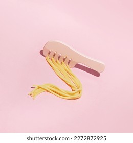 Cooked spaghetti and hair comb, creative aesthetic layout, hair care idea. 