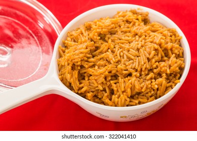 Cooked Spanish Rice In Serving Bowl Against Red Background.