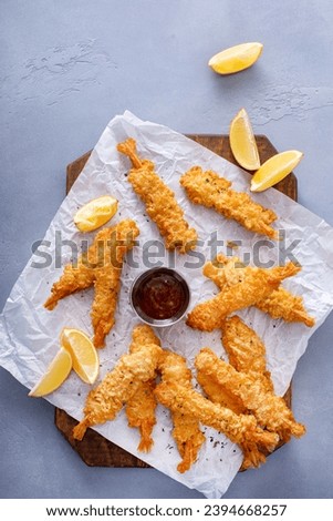 Cooked tempura shrimp on a serving board with dipping sauce freshly made and ready to eat