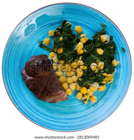 Cooked veal meat and vegetable side dish, top view. Boiled chickpeas with spinach perfectly complement baked veal. Isolated over white background.