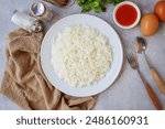 Cooked white rice or steamed rice in a white plate, with spoon and fork and eggs, thai jasmine rice, thai fragrant rice, top view food table	