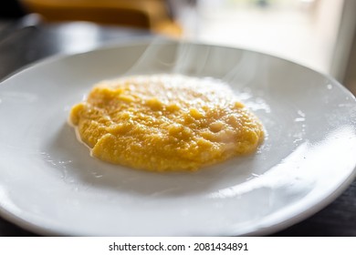 Cooked yellow southern american corn grits on plate as breakfast porridge with hot steam rising and texture of healthy cereal - Shutterstock ID 2081434891
