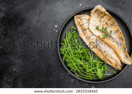 Cooked zander fillets, also known as walleye or pike perch, seared and plated with greens