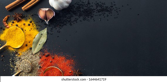 Cookery. Banner. Spices and herbs on a black background. Copy space for text or label. View from above. Flat lay.