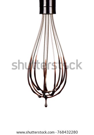 Cookery wire whisk with splashing chocolate isolated on white background with clipping path. Chocolate drop.