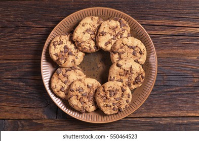 Cookie With Chocolate In Red Plate On Dark Wooden Background, Top View