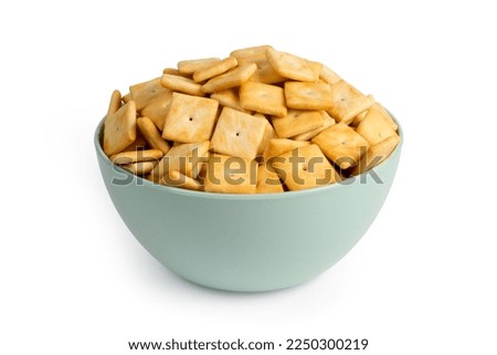 Cookie crackers in a plate on a white background. Lots of salty cookies on a plate.
