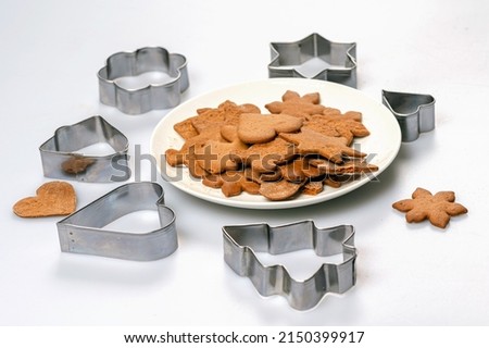 cookie cutters and freshly baked gingerbread on a white plate, isolated, copy space, close-up