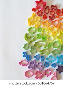 Cookie cutters are plastic. The colors of the rainbow for kids. Homemade pastries. White background.