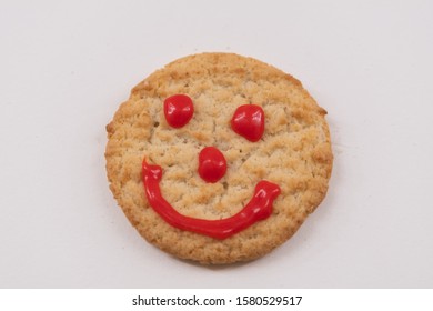 Cookie Decorated With Red Royal Icing Sugar,  Red Smiley Face. Happy Emotion On Cookie. Isolated, White Background. Selective Focus