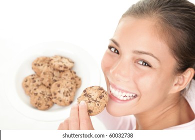 Cookie woman eating chocolate chip cookies. Cute young mixed race chinese / caucasian model on white background.