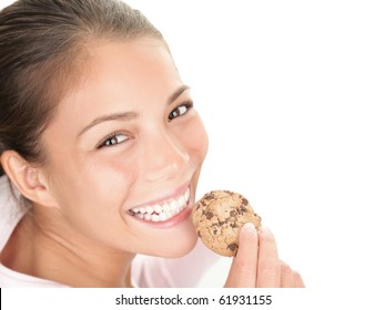 Cookie woman eating chocolate chip cookies on white background. Cute young mixed race chinese / caucasian woman smiling.