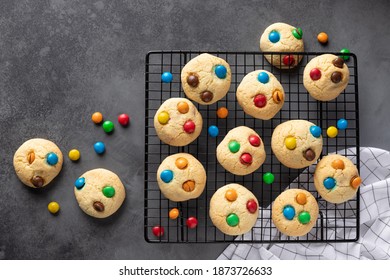 Cookies with colorful candies on baking sheet. Birthday, food, pastry background, greeting card. dark background. horizontal image. flat lay. copy space