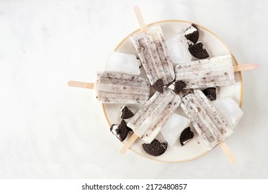 Cookies And Cream Ice Pops On A Plate. Overhead View On A White Marble Background.