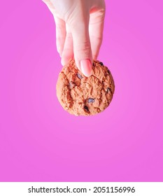 Cookies In Hand. Chocolate Chip Cookies. Pink Background