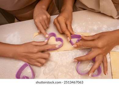 Cookies Heart Cutters Kitchen - Two hands are using heart-shaped cookie cutters to cut out shapes from dough. - Powered by Shutterstock