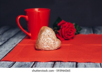 cookies in the shape of a red heart kruzhka.krasnaya rose on a red napkin