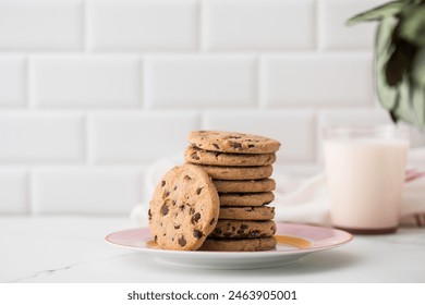 Cookies are spread out on a plate, a glass of fresh milk. Homemade cookies with chocolate chips. - Powered by Shutterstock