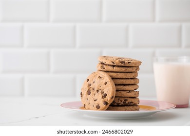 Cookies are spread out on a plate, a glass of fresh milk. Homemade cookies with chocolate chips. - Powered by Shutterstock
