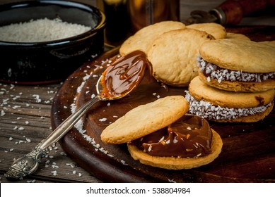 Cooking alfajores - a traditional dessert from Latin America or Mexico. Shortbread cookies with dulce de leche and coconut