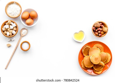 Cooking American Pancakes. Ingredients, Cakes, Nuts And Honey On White Background Top View Copyspace