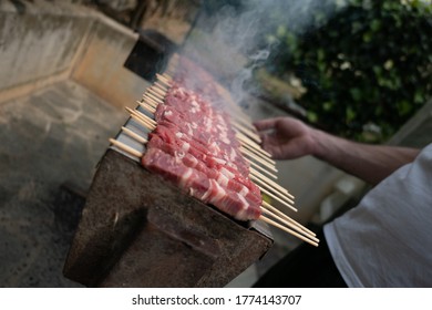 Cooking arrosticini at home, grill outdoor, roasted lamb. Abruzzo, Italy