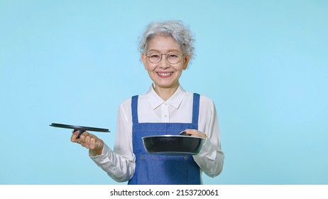 Cooking Asian Senior Woman With An Apron.