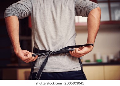 Cooking, back and man tie apron in kitchen for dinner, food or supper for event at home. Hands, party and closeup of male chef with culinary fabric for preparing evening meal with hygiene in house. - Powered by Shutterstock