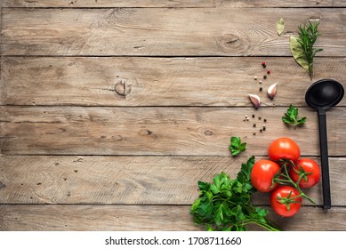 Cooking background, healthy eating concept. Ripe tomatoes, spoon, herbs and spices on wooden background, top view, copy space.