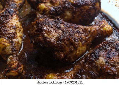 Cooking baked authentic spicy Jamaican jerk chicken legs in oven using casserole dish