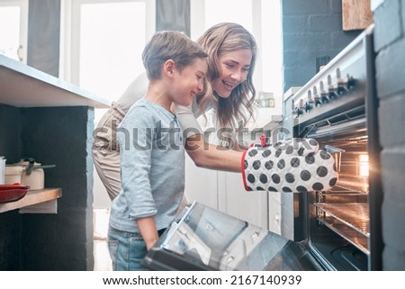 Cooking and baking is both physical and mental therapy. Shot of a little boy and his mother sitting in front of the oven.